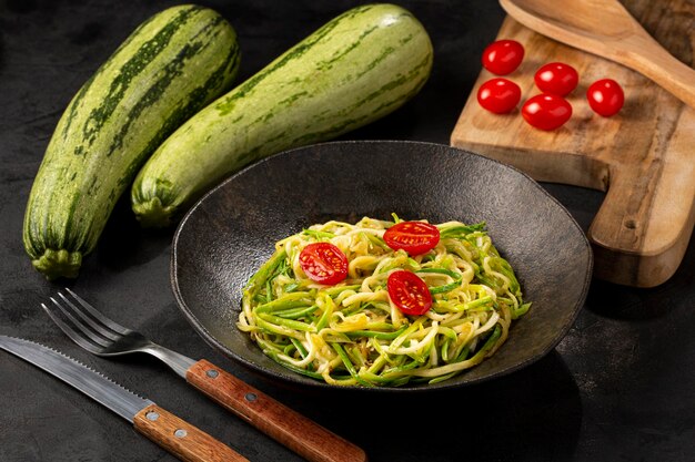 Zucchini spaghetti with tomatoes in garlic and oil