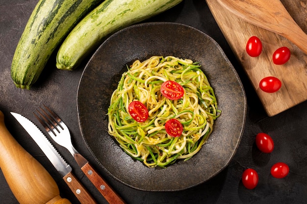 Zucchini spaghetti with tomatoes in garlic and oil