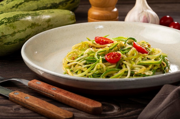 Zucchini spaghetti with tomatoes in garlic and oil