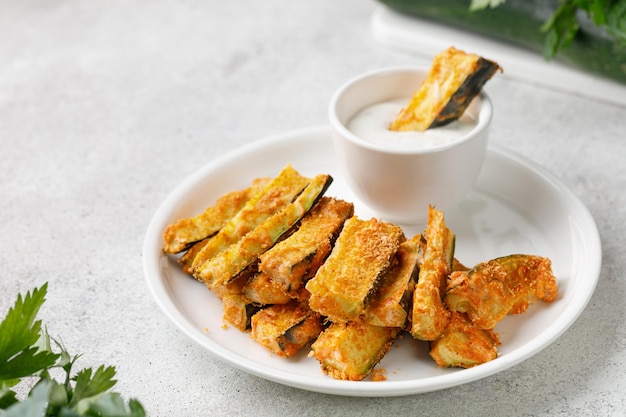 Zucchini sticks baked with cheese herbs breadcrumbs and cream yogurt sauce Roasted Zucchini snack