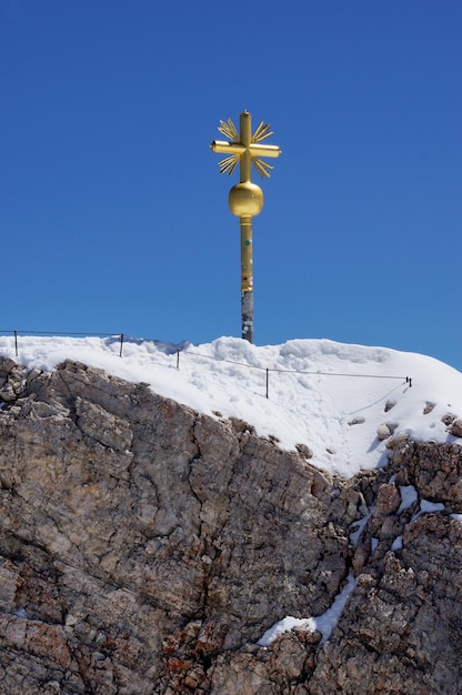 사진 푸른 하늘과 눈 덮인 산봉우리가 있는 추크슈피체(zugspitze) 정상 십자가