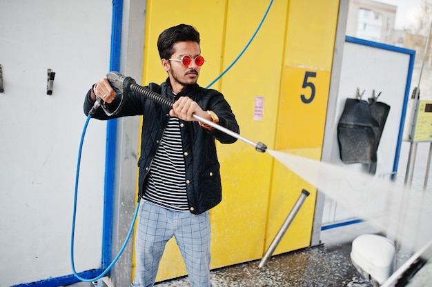 Zuid-Aziatische man of Indiase man zijn witte vervoer wassen op autowassen.