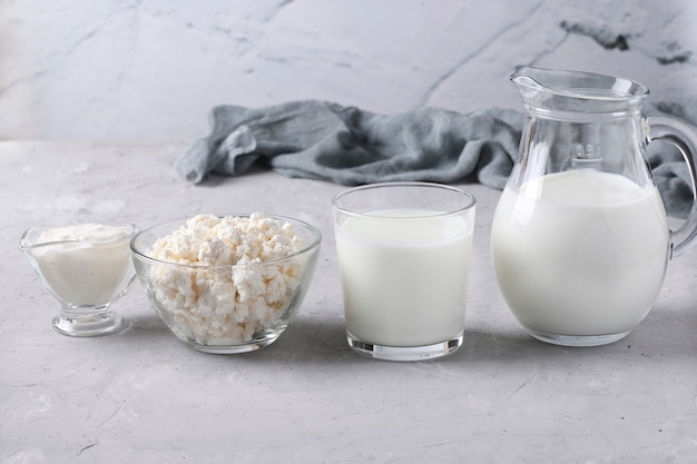 Foto zuivelproducten melk, kefir of ayran, kwark en zure room in een doorzichtige kom