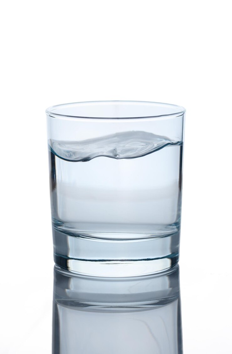 Foto zuiver drinkwater in een glas of beker geïsoleerd op een witte achtergrond foto van hoge kwaliteit