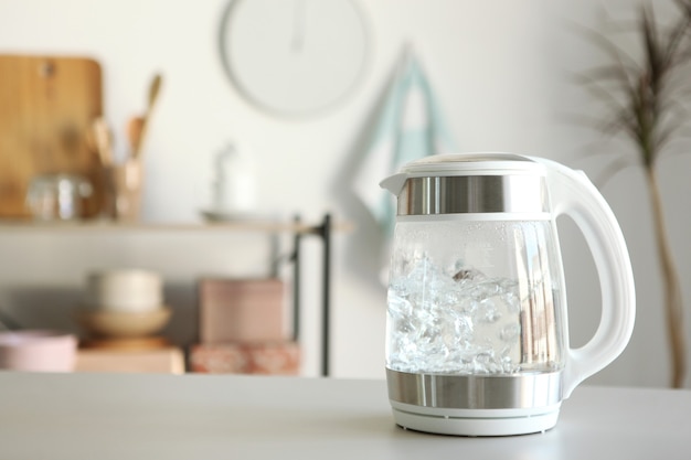 Zuiver water kookt in een waterkoker op de tafel in de keuken