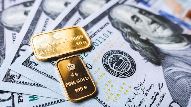 Zuivere goudstaaf en Amerikaanse dollarbiljetten vertegenwoordigen het zakelijke en financiële concept