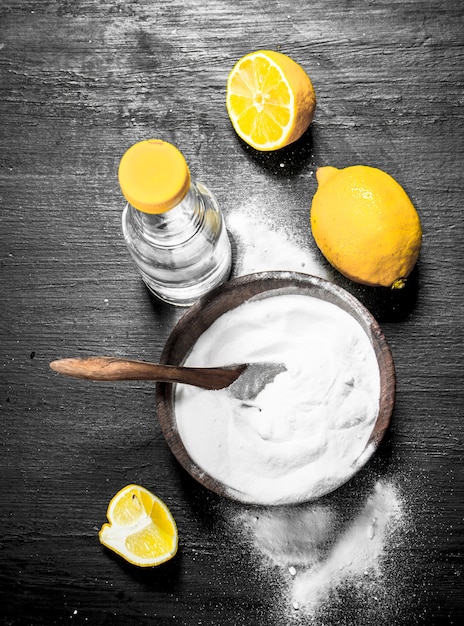 Zuiveringszout in een kom met azijn en schijfjes citroen.
