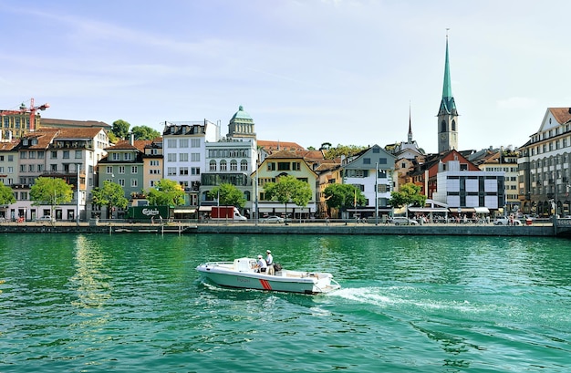 Zurich, Switzerland - September 2, 2016: Fraumunster Church and motor boat Limmat River quay in the city center of Zurich, Switzerland. People on the background