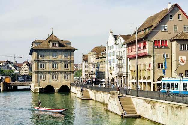 Zurich, Switzerland - September 2, 2016:  Person in boat at Old Town Hall in Limmat River in Zurich, Switzerland