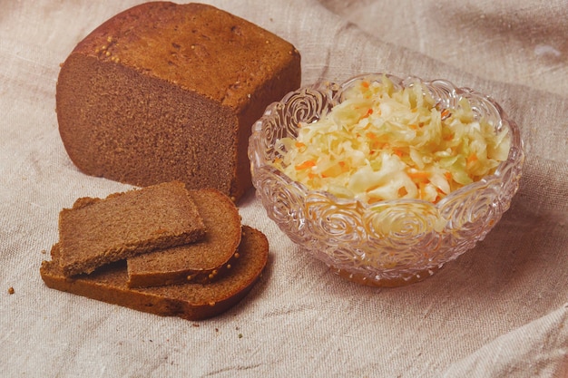 Zuurkool in een bord en een stuk brood op een zak