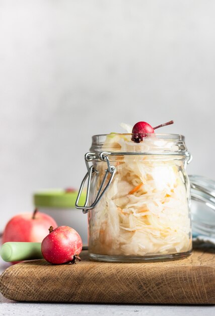 Zuurkool met appel in glazen pot. Gefermenteerde Kool. Probiotica eten.