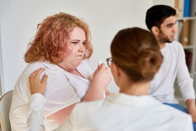 Zwaarlijvige jonge vrouw huilen in steungroepsessie