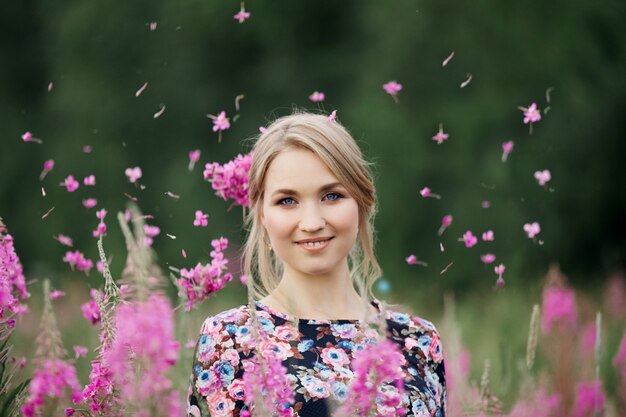 Zwanger meisje dat op gebied van bloemenwilgeroosje loopt