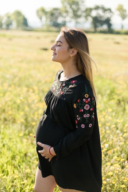 Zwanger meisje in zonnebloemen gelukkig meisje dat op de baby wacht