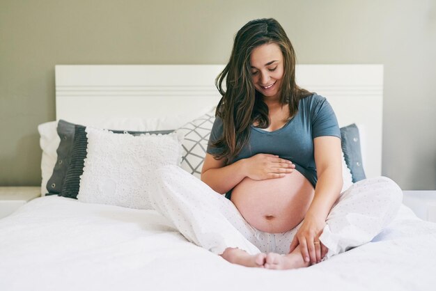 Zwanger zijn is puur geluk Shot van een jonge zwangere vrouw die thuis ontspant