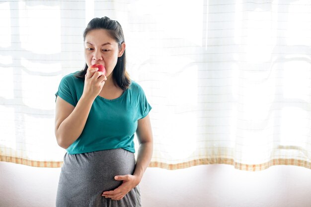 Zwangere aziatische vrouw die zich in moederschapskleren bevindt