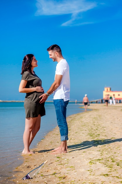 Zwangere gelukkige paar op strand