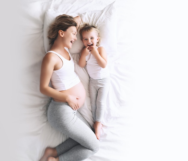 zwangere moeder en dochter rustende jonge vrouw met haar eerste kind tijdens de tweede zwangerschap