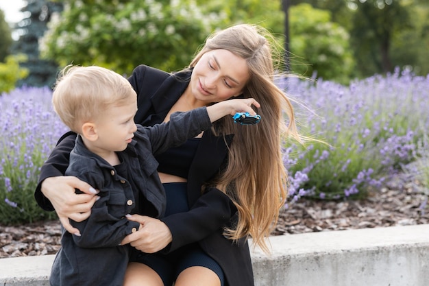 Zwangere moeder en haar zoontje brengen samen tijd door in het park knuffelen en glimlachen