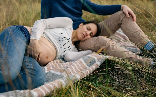 Zwangere slaap op een deken op het gras