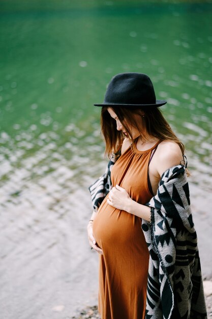 Foto zwangere vrouw bij het meer.