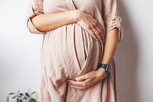 Zwangere vrouw buik close-up handen knuffelen buik Concept van de gezondheid van de moeder