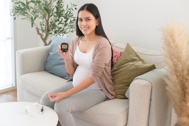 Zwangere vrouw controleert haar bloedsuikerspiegel met behulp van een digitale glucosemeter