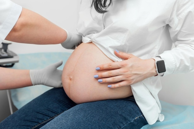 Zwangere vrouw die echografie ondergaat op het kantoor van de gynaecoloog