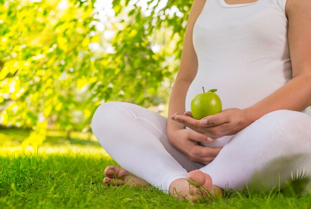 Zwangere vrouw die groene appel houdt