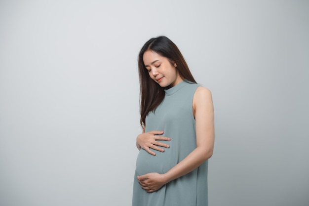 Foto zwangere vrouw die haar buik vasthoudt en handhartvorm maakt geïsoleerd op witte achtergrond familie moeder moeder zwanger concept