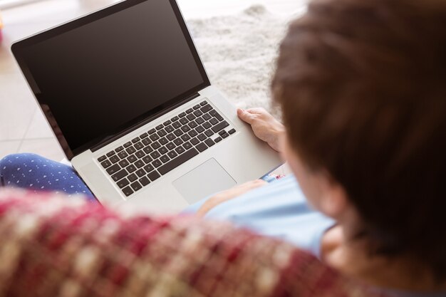 Zwangere vrouw die haar laptop met behulp van