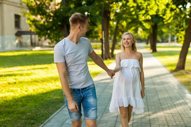 Zwangere vrouw die met haar echtgenoot in een park loopt