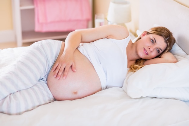 Zwangere vrouw die op bed ligt