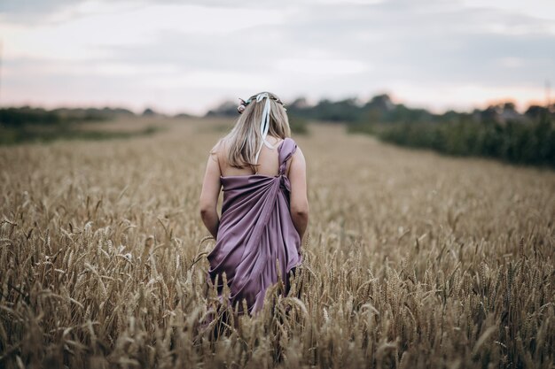 Zwangere vrouw die op het tarwegebied loopt