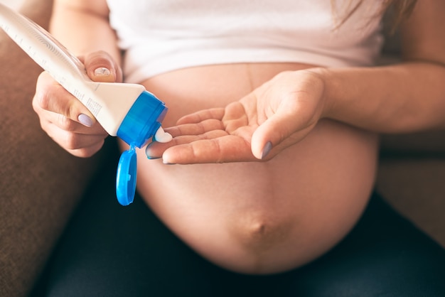 Zwangere vrouw die room houdt en op grote buik toepast