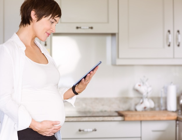 Zwangere vrouw die tabletpc met behulp van