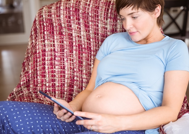 Zwangere vrouw die tabletpc met behulp van