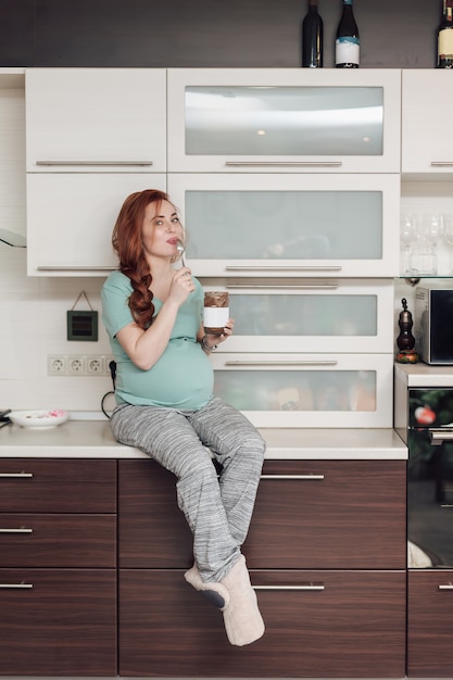 Zwangere vrouw die van het eten van chocolade geniet