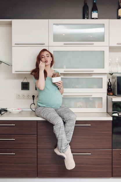 Zwangere vrouw die van het eten van chocolade geniet