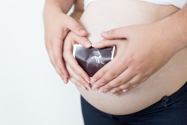 zwangere vrouw en echtgenoot die een echografie van de foetus houden