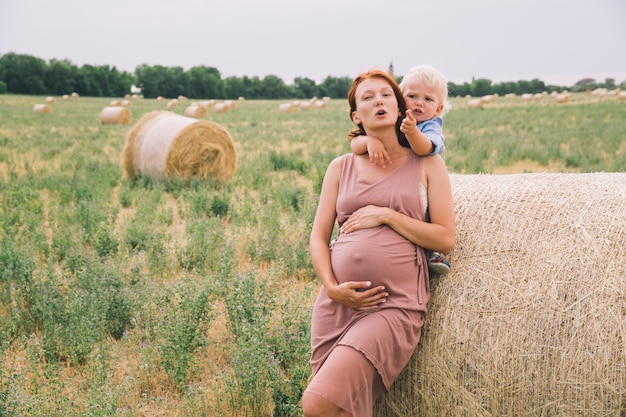 Zwangere vrouw en zoon in de natuur Moeder wacht op een tweede baby