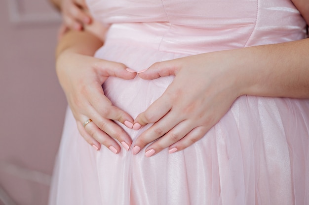 Foto zwangere vrouw haar buik close-up aan te raken