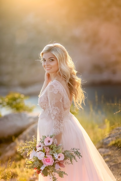 Zwangere vrouw in de natuur. Mooie vrouwen toekomstige moeder in witte lange kleding in openlucht