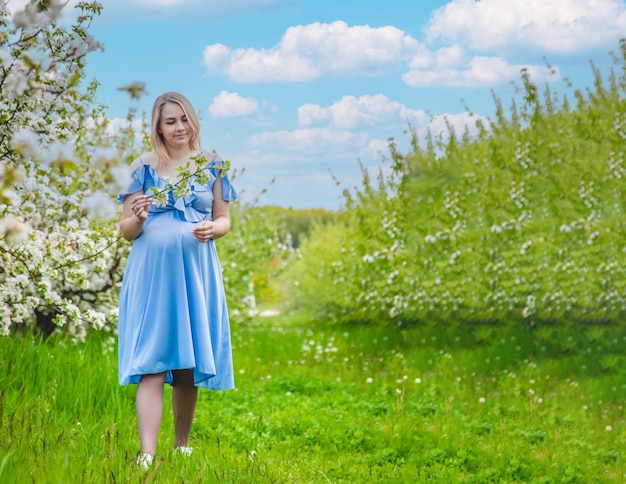 Zwangere vrouw in de tuin van bloeiende appelbomen Selectieve aandacht