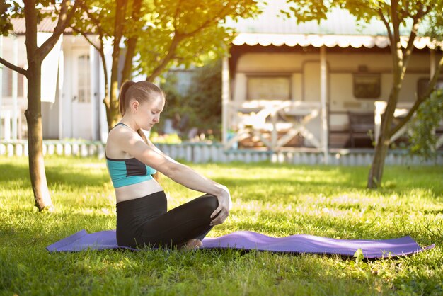 Zwangere vrouw in de yoga van tuinpraktijken