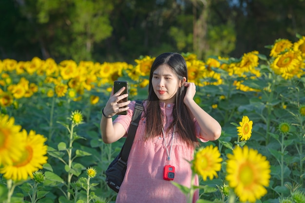 Zwangere vrouw in een zonnebloem veld