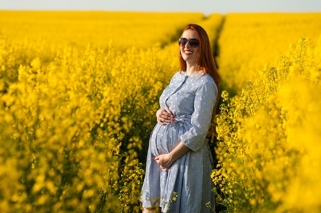 Zwangere vrouw in geel veld