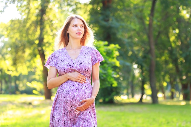 Zwangere vrouw in het park kijkt weg