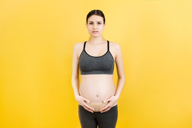 Zwangere vrouw in verband tegen rugpijn
