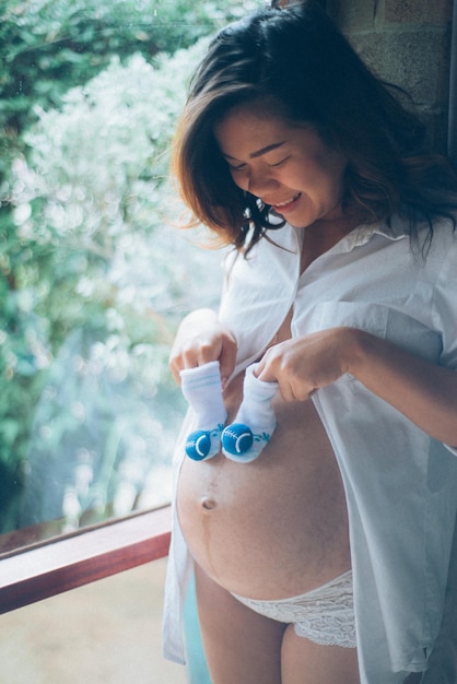 Zwangere vrouw met baby laarzen tegen haar buik